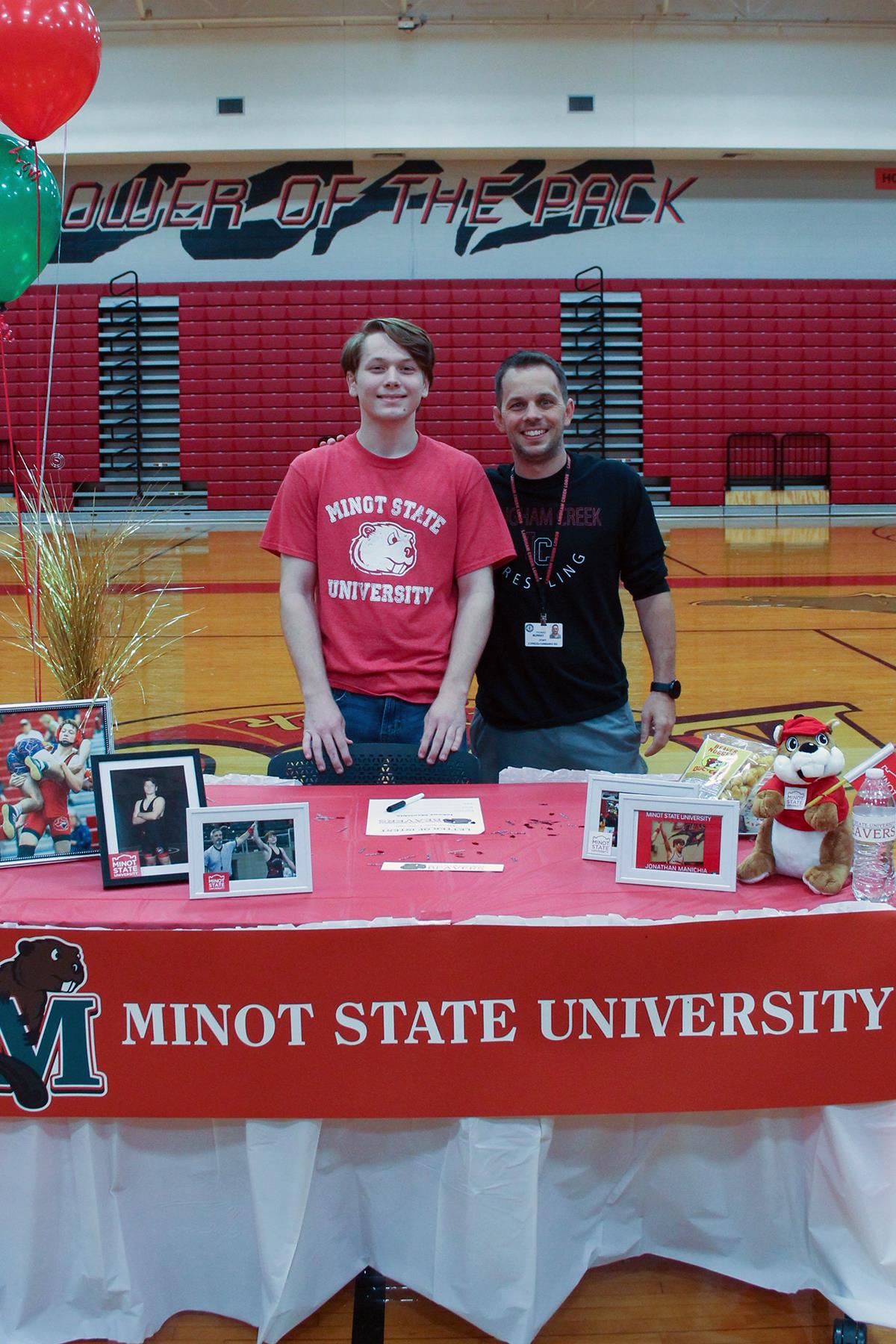 Langham Creek High School senior Johnny Manichia, left, signed a letter of intent to wrestle at Minot State University.